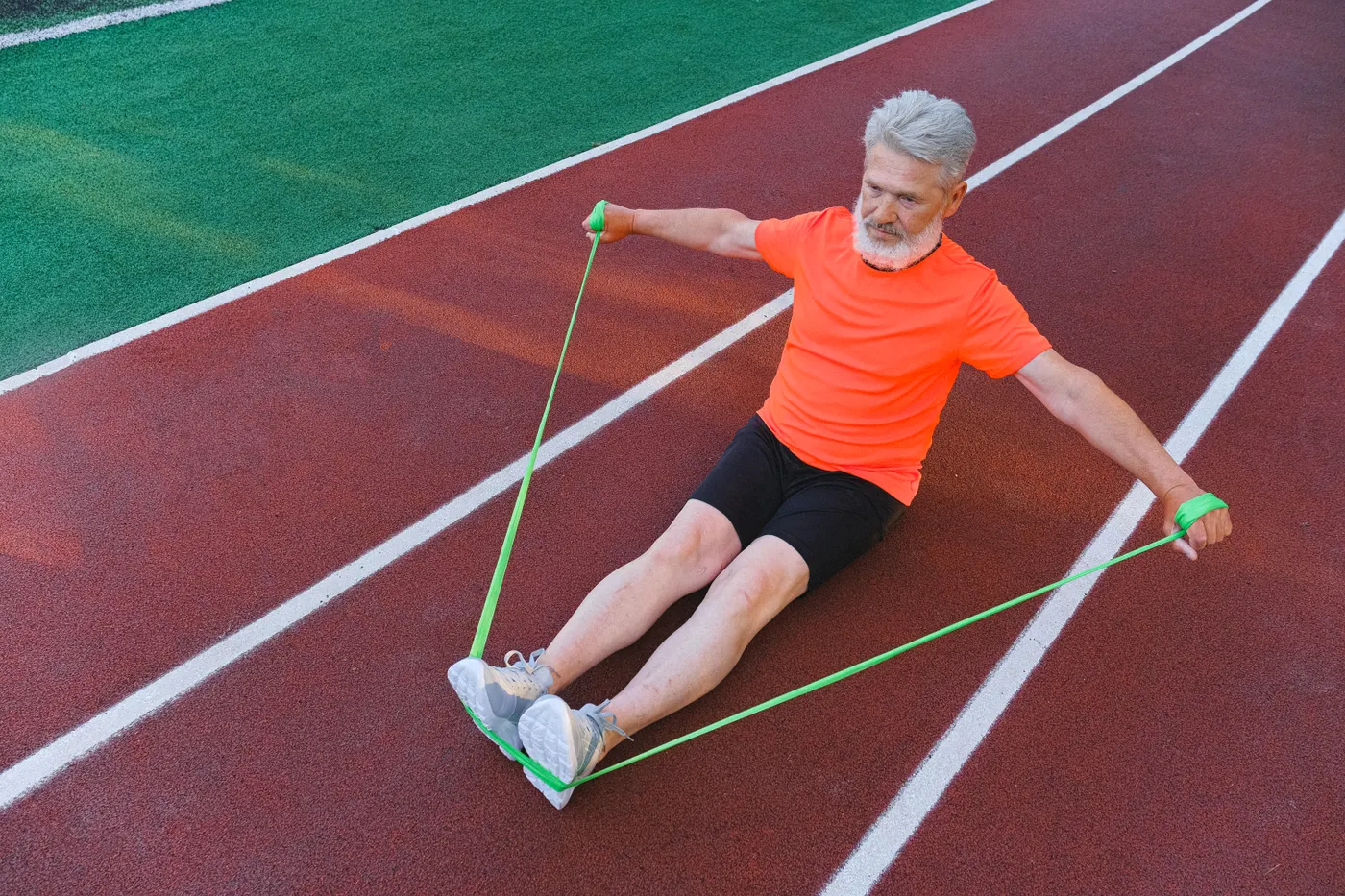Senior man training with an elastic resistance band outdoors