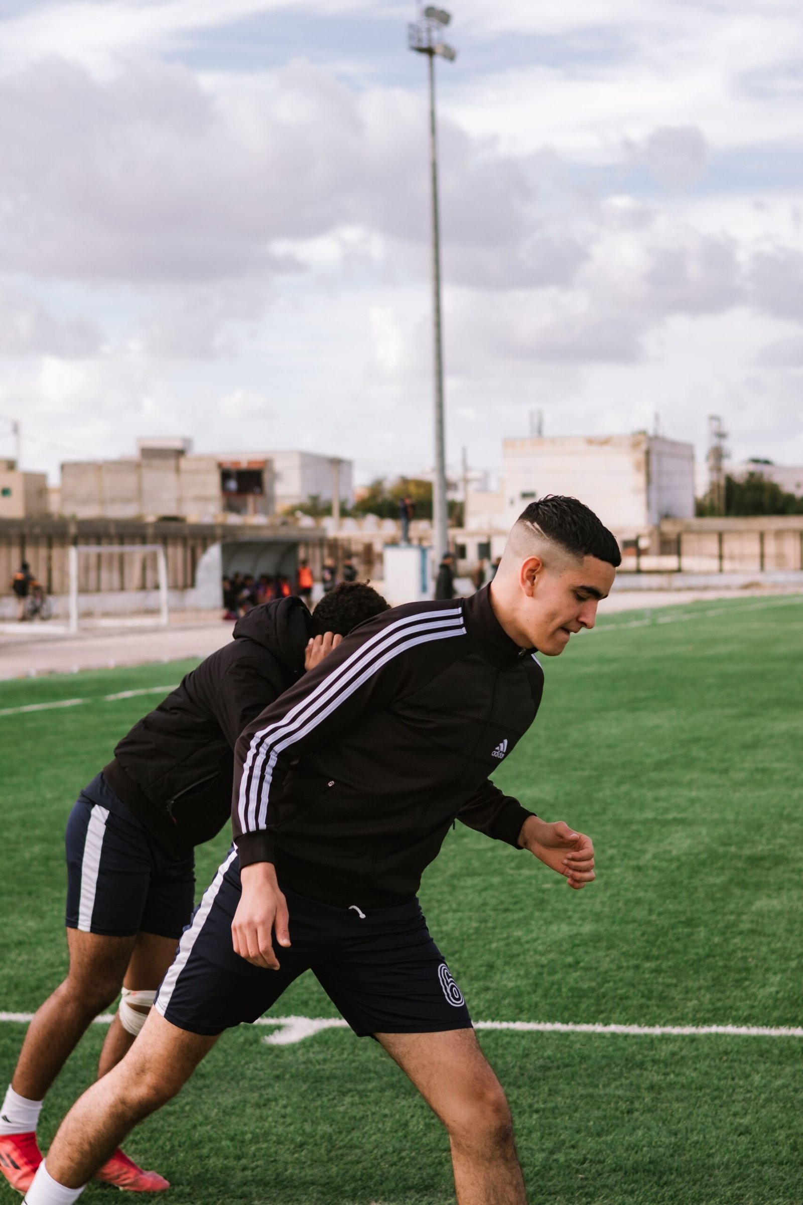 Two football players performing a warm-up on the pitch