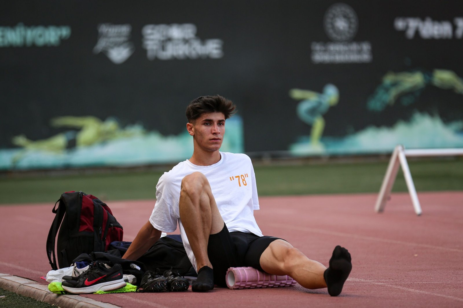 Athlete rolling a leg on a track after training