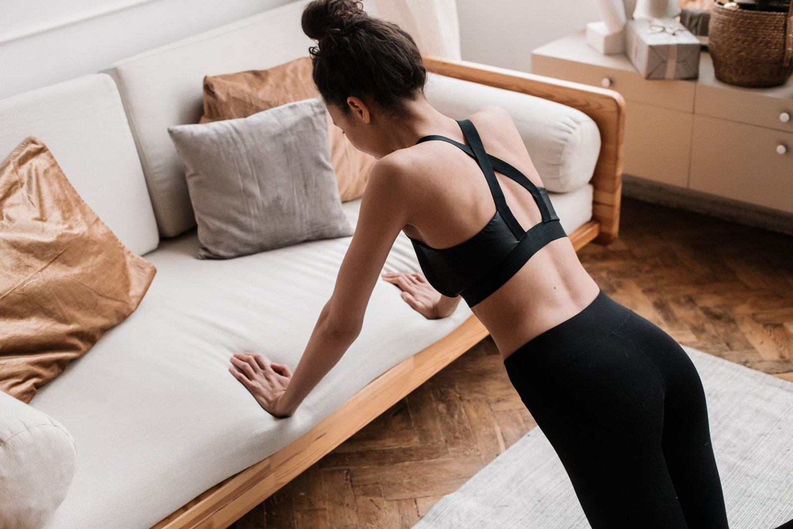 Woman performing an incline push-up against a sofa during a short bodyweight session