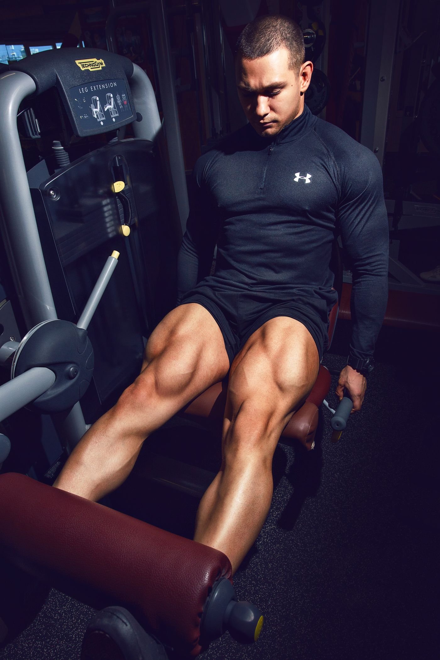 Man seated at a leg-extension machine training his quadriceps