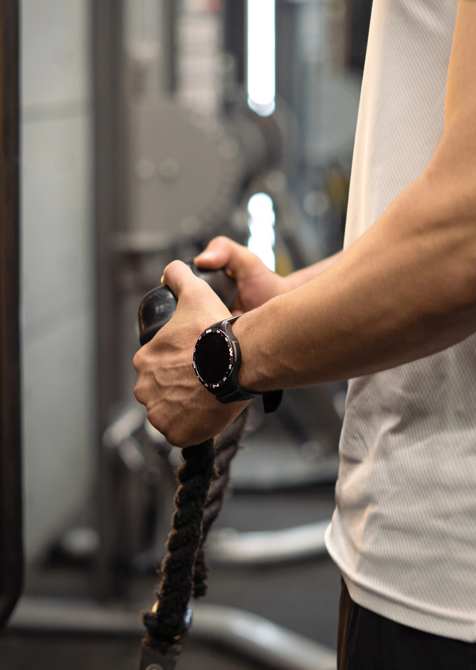 Hands gripping a cable machine handle during strength training