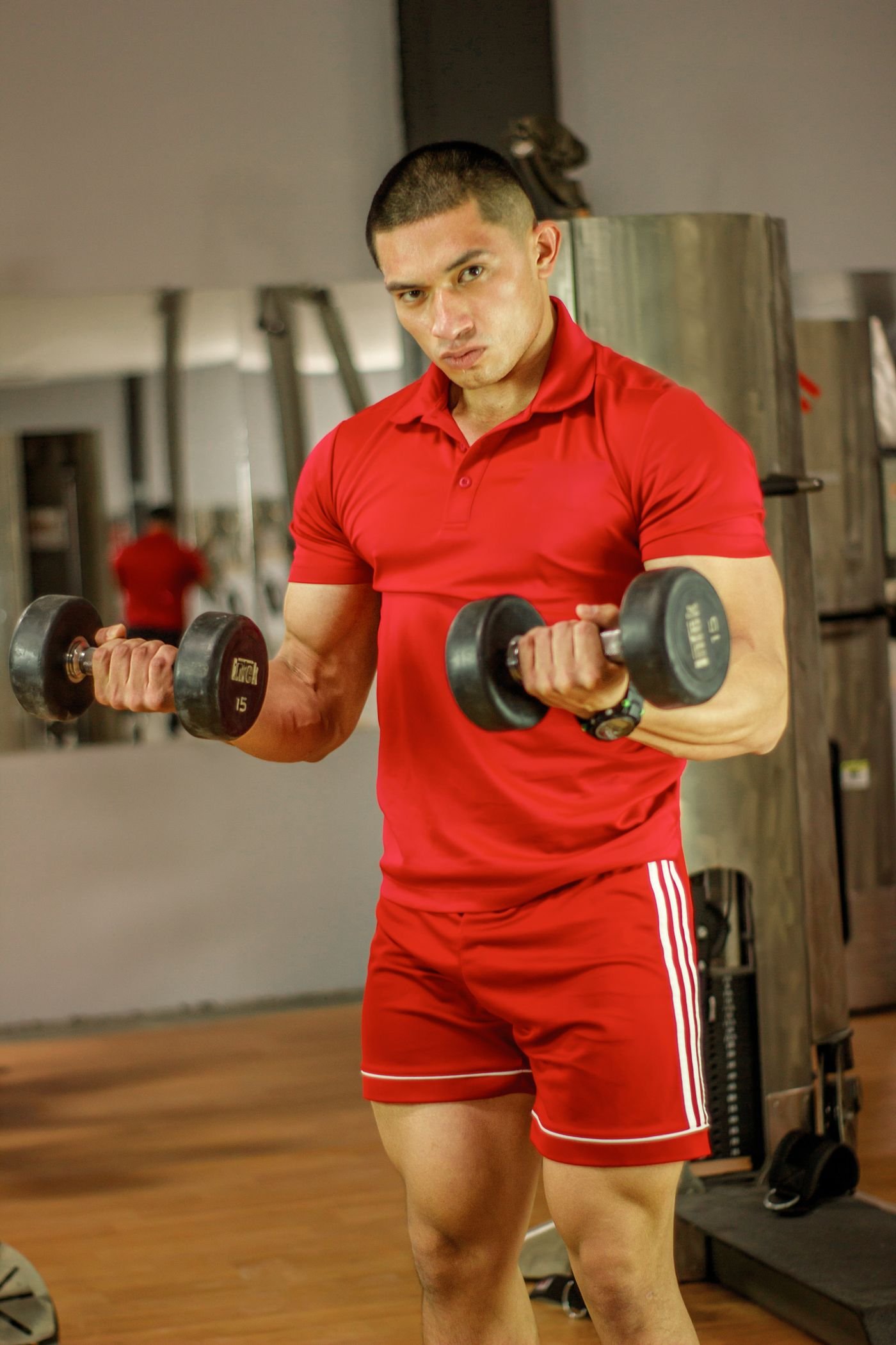 Lifter performing a controlled dumbbell curl in a gym