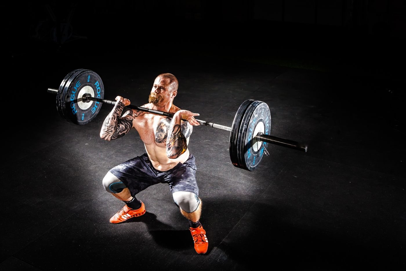 Man performing a barbell power clean in a gym