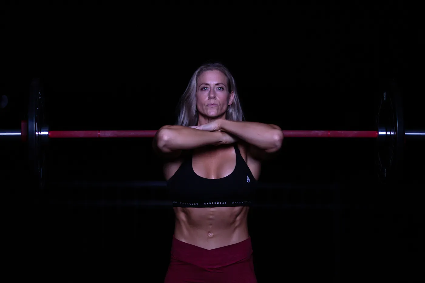 Woman lifting a barbell in a strength-training gym