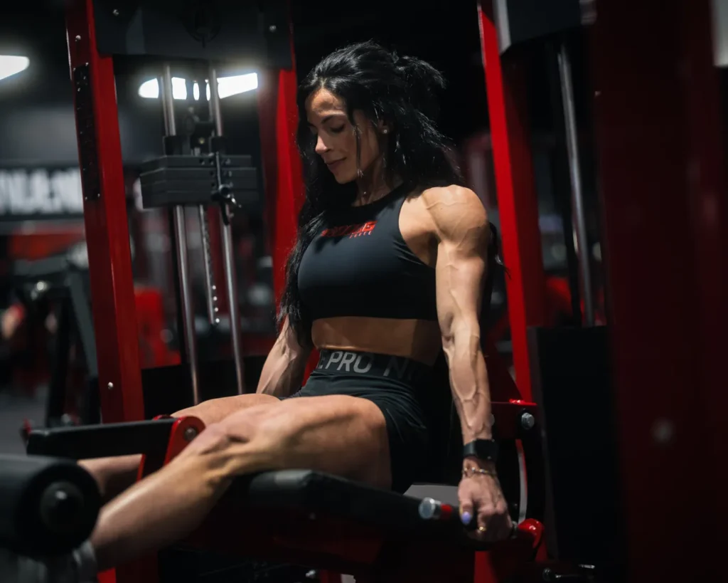 Female bodybuilder lifting weights in a gym during resistance training