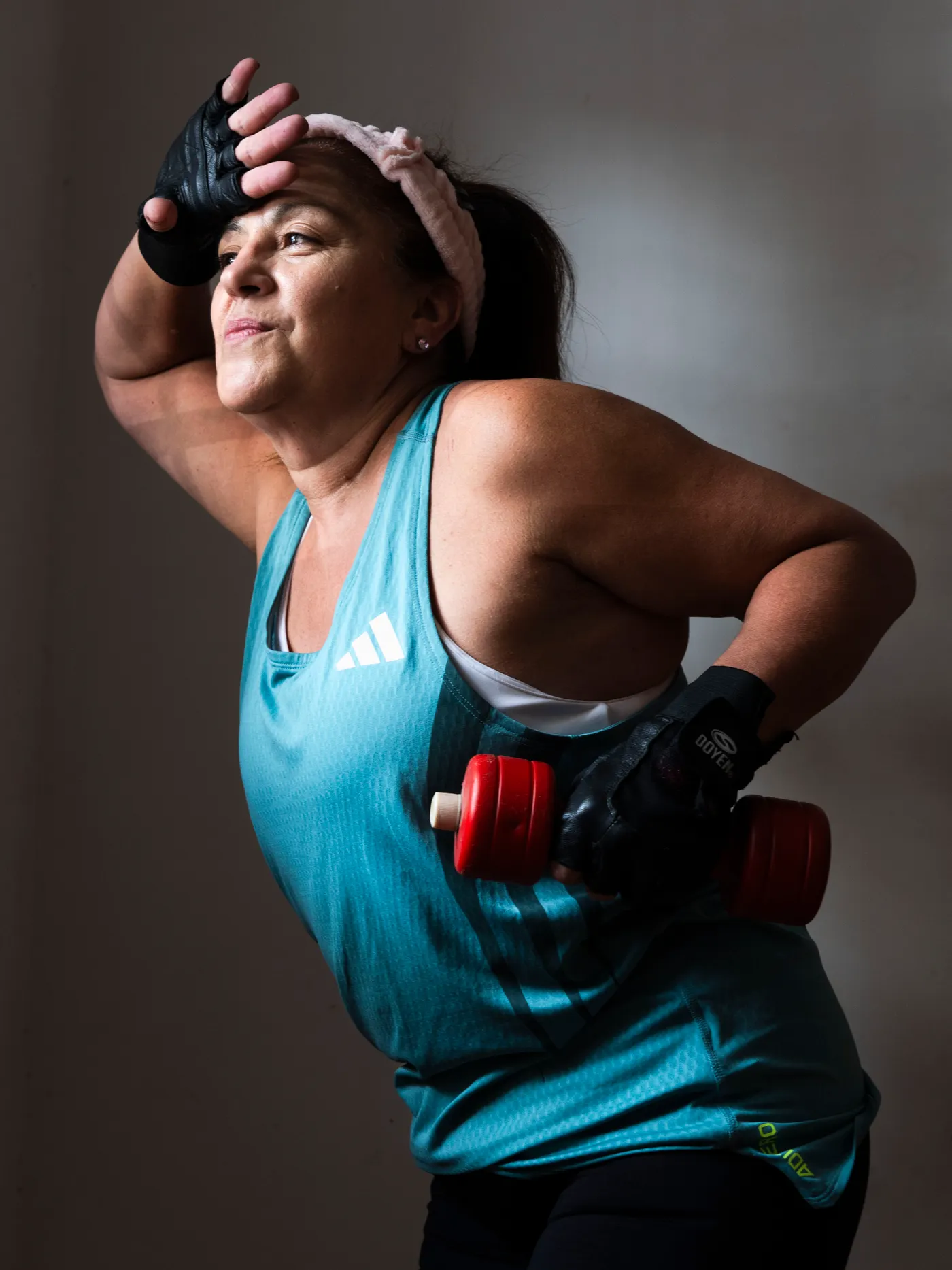 Middle-aged woman exercising with dumbbells indoors