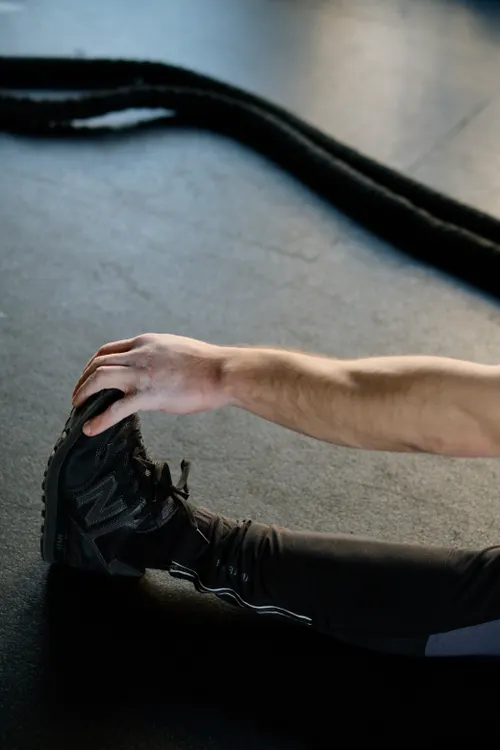 Athlete stretching on the gym floor after training