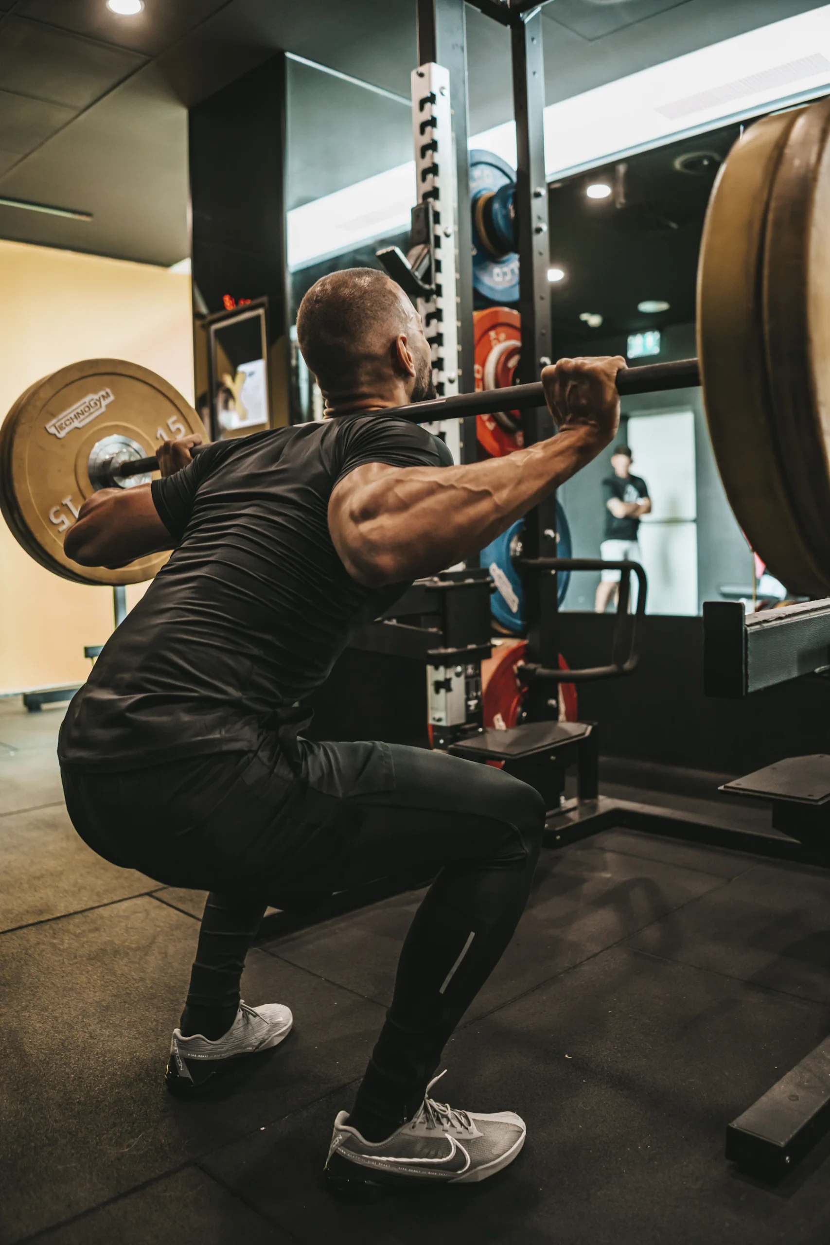Lifter holding a barbell across his upper back during squat training