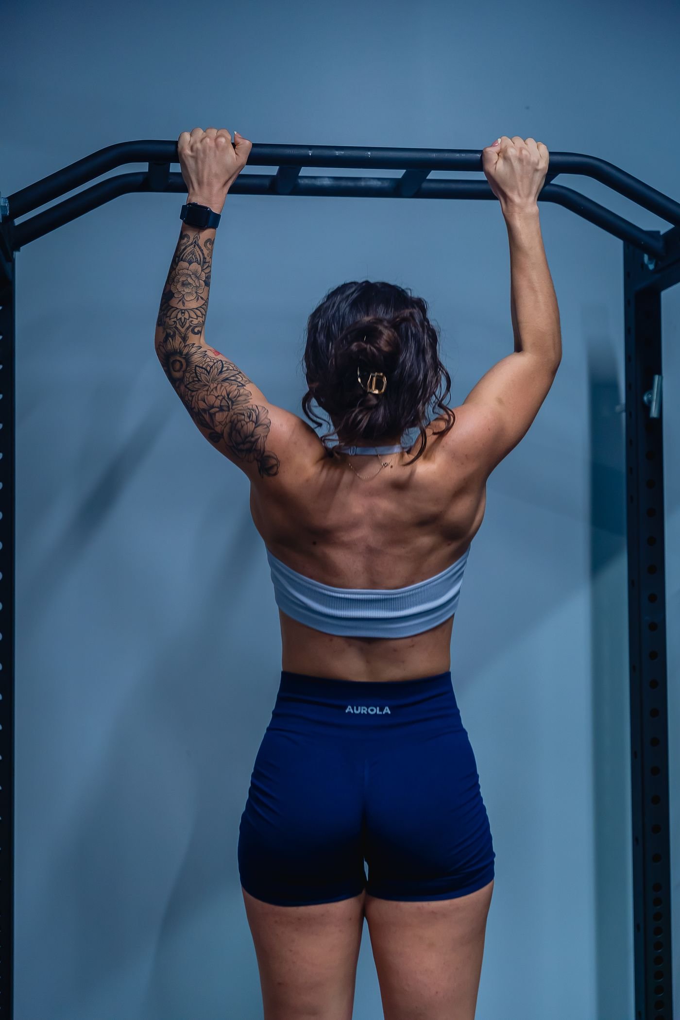 Woman training her upper body on a pull-up bar