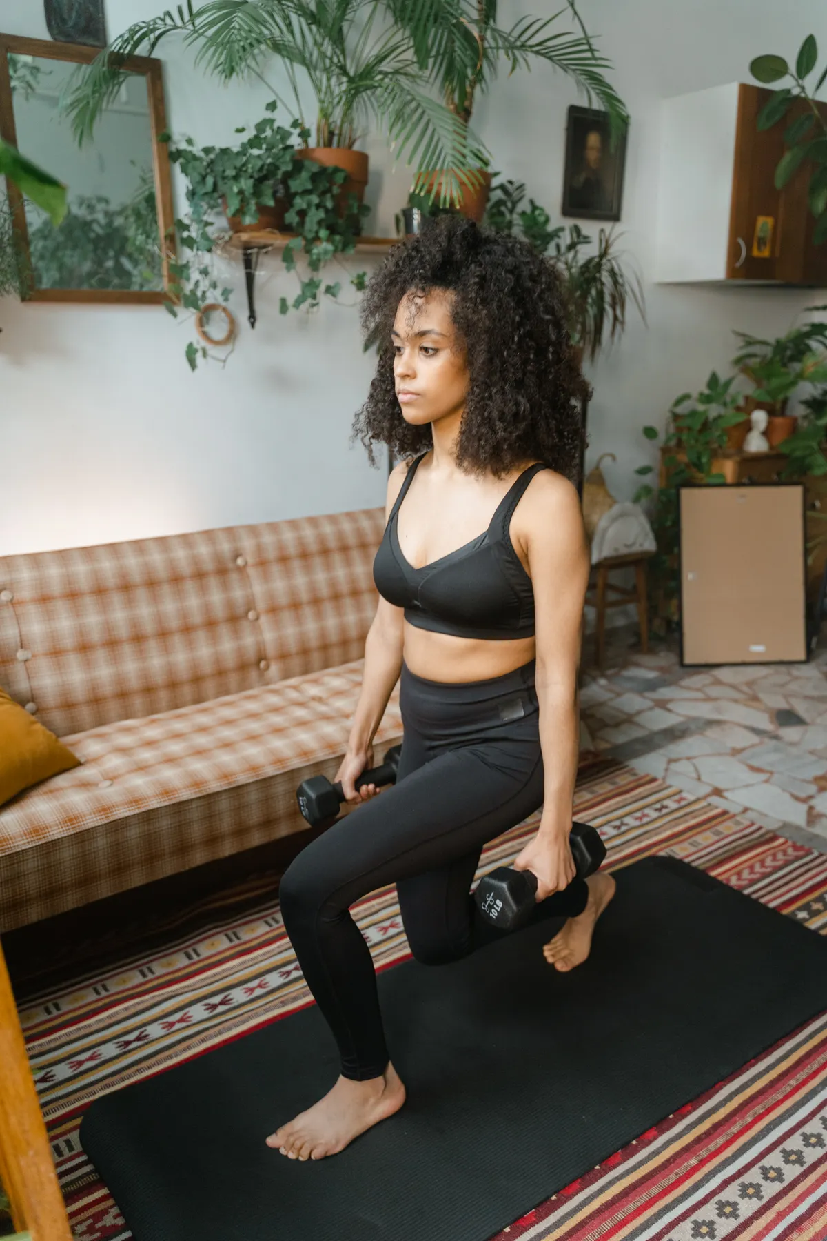 Woman controlling a split-stance lunge with dumbbells