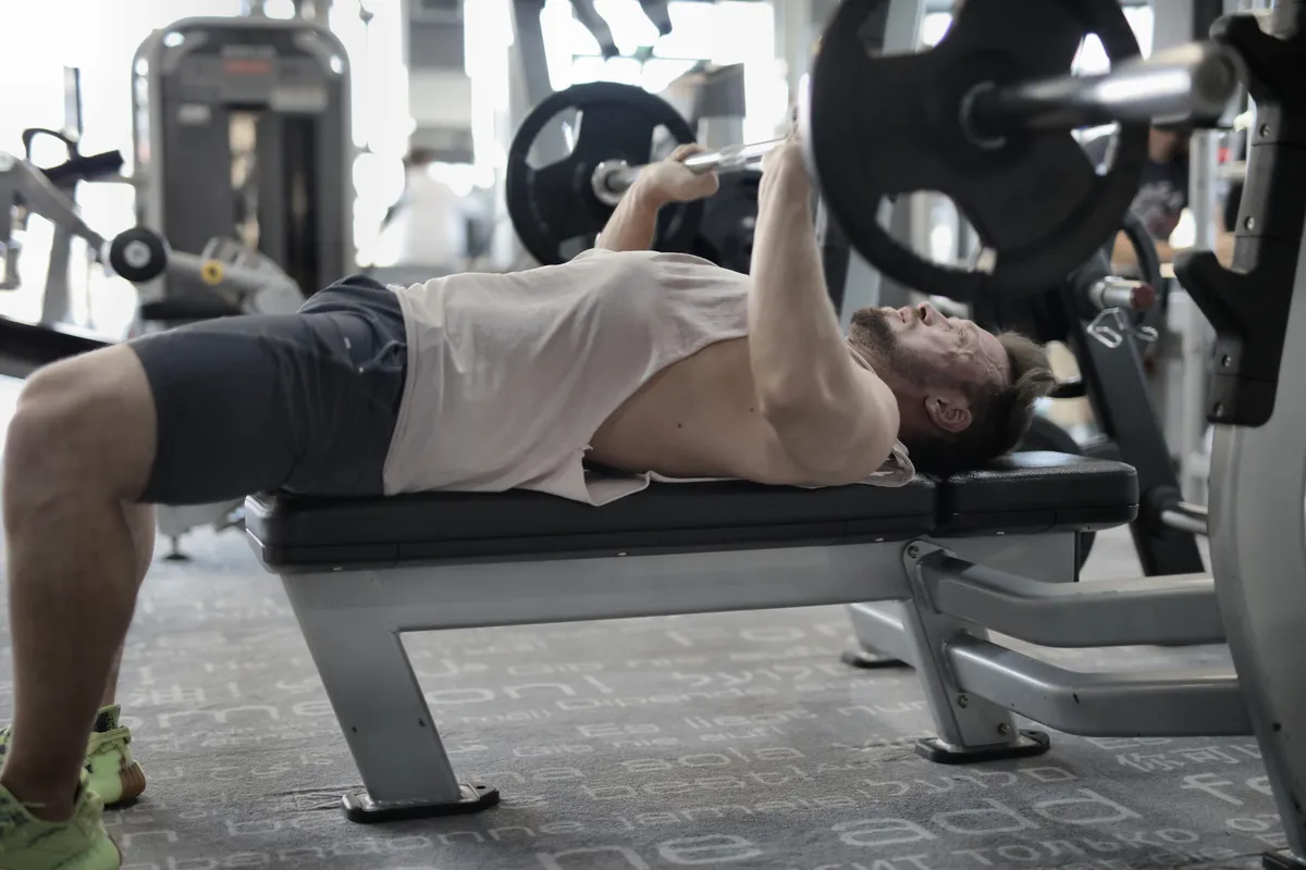 Athlete pressing a barbell on a weight bench