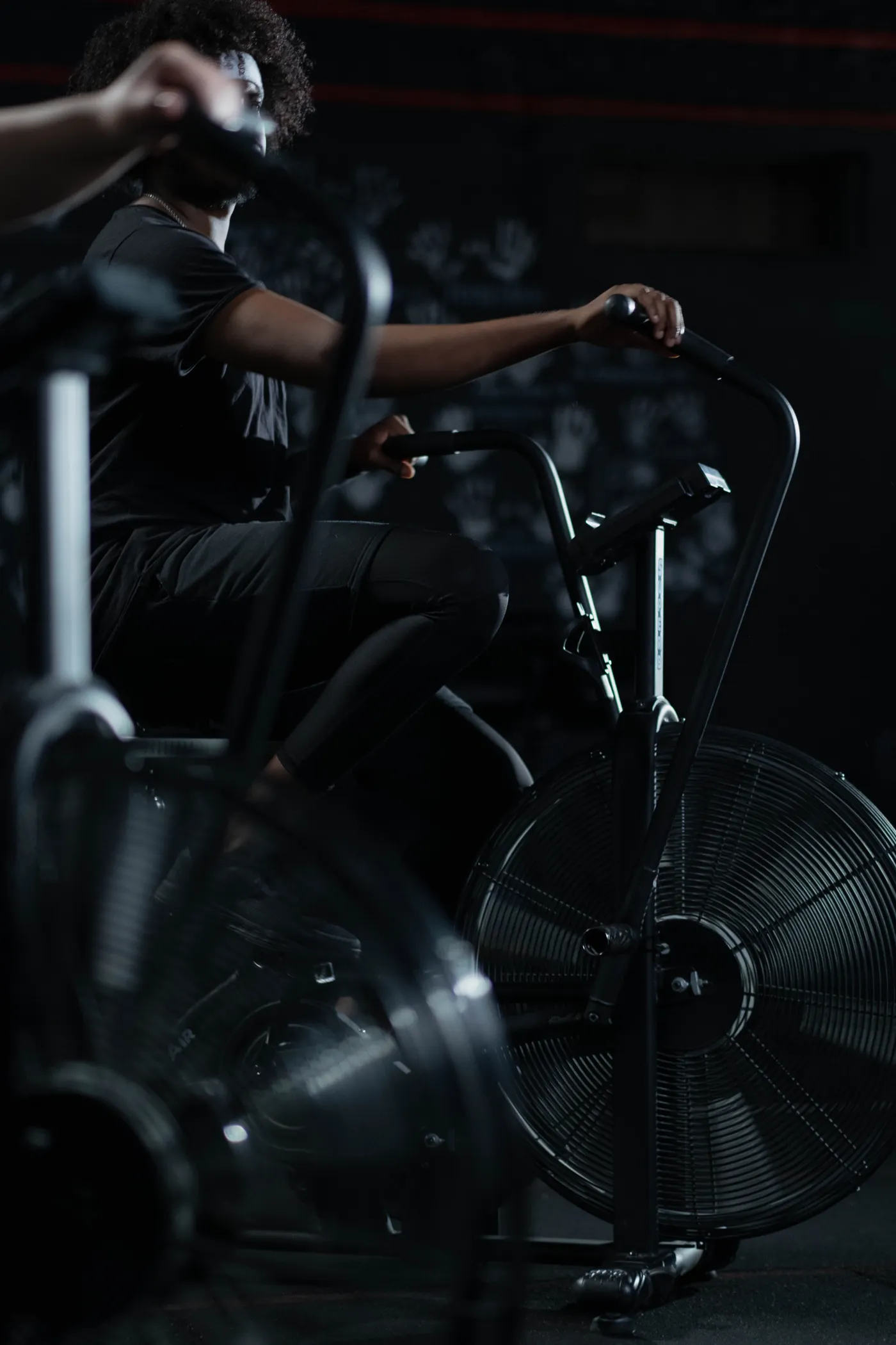 Person pedaling a stationary exercise bike in a gym