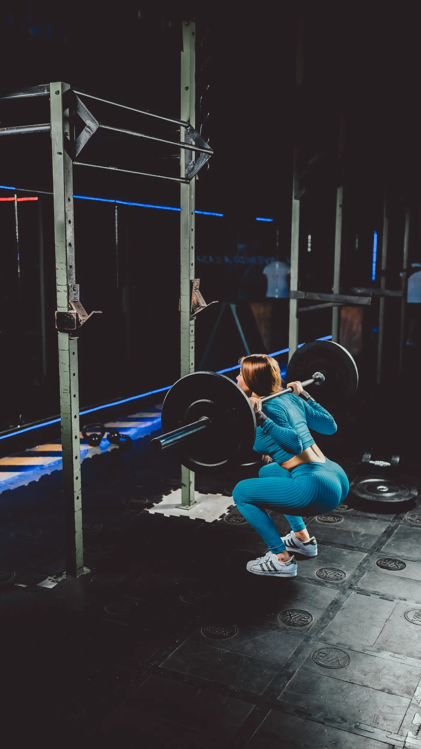 Woman performing a barbell squat in a gym