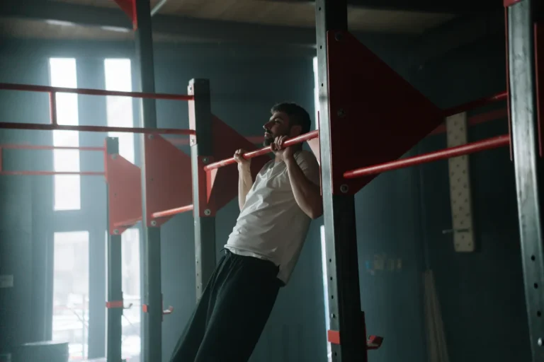Man performing a strict pull-up in an indoor gym