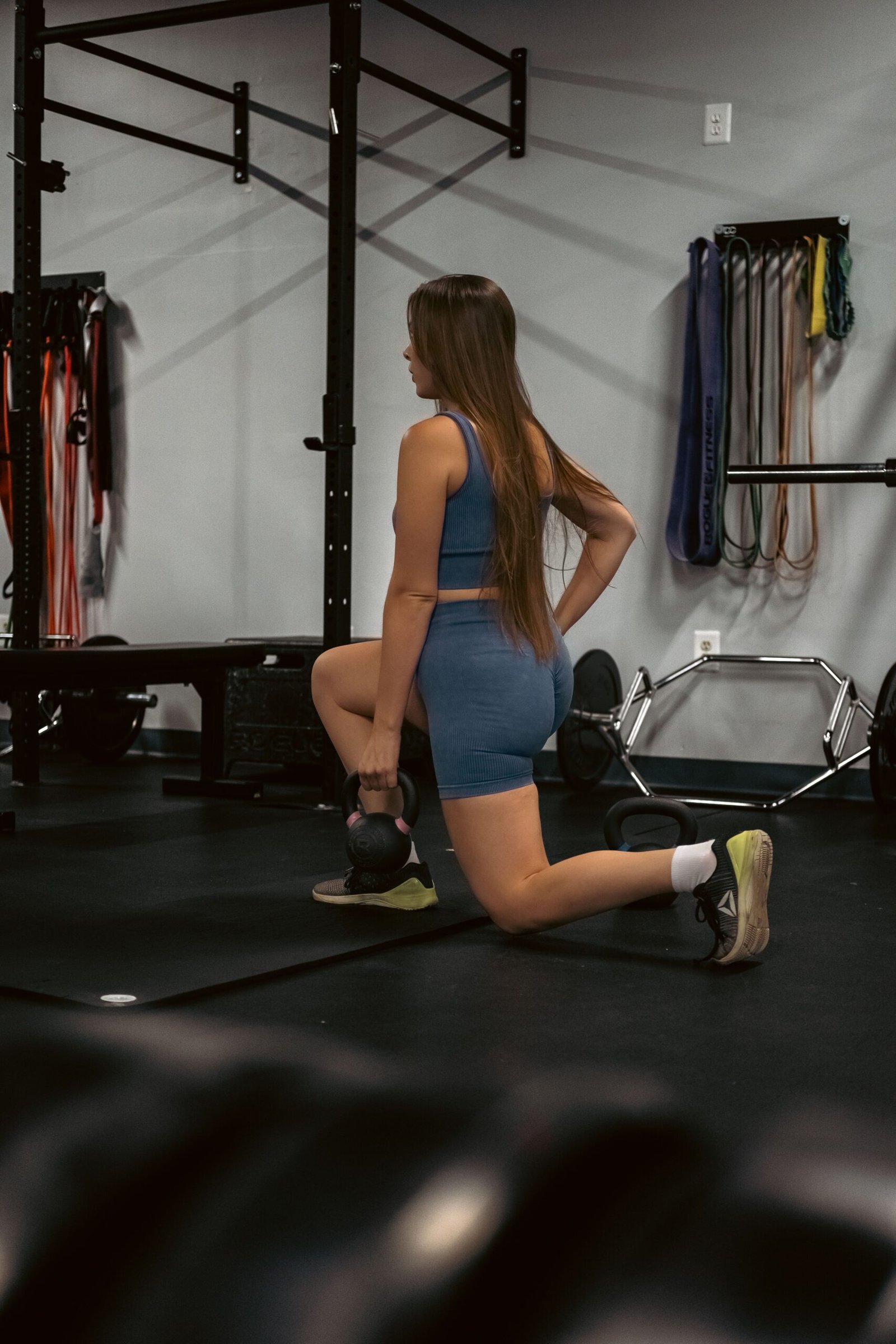 Woman performing a kettlebell lunge during single-leg strength training