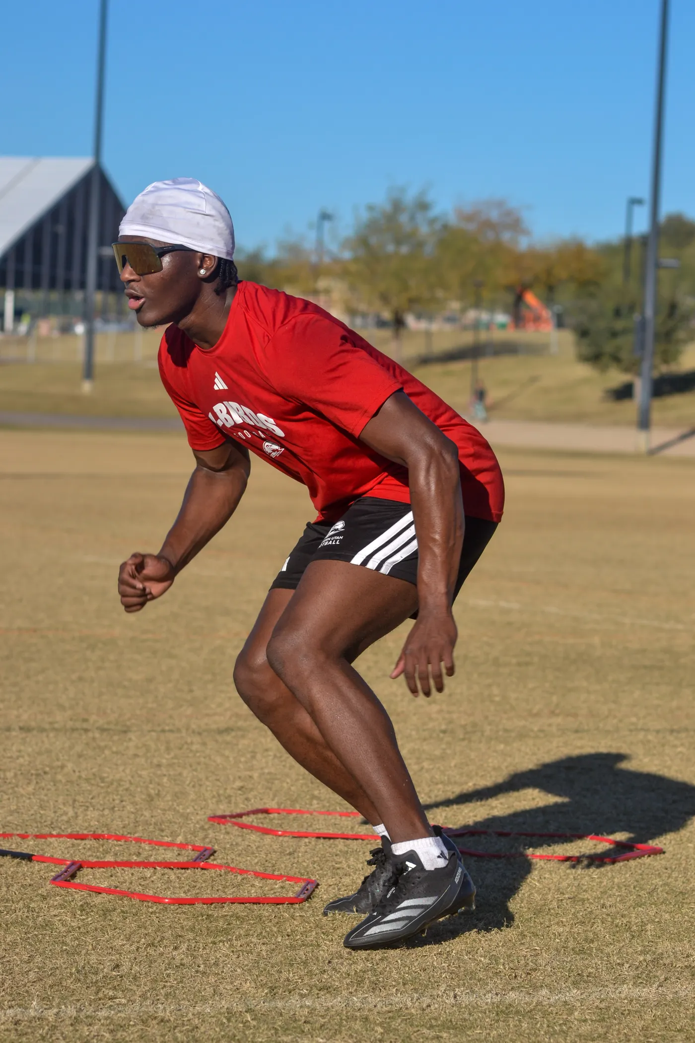 Teenage athlete performing agility drills on a sunny outdoor field