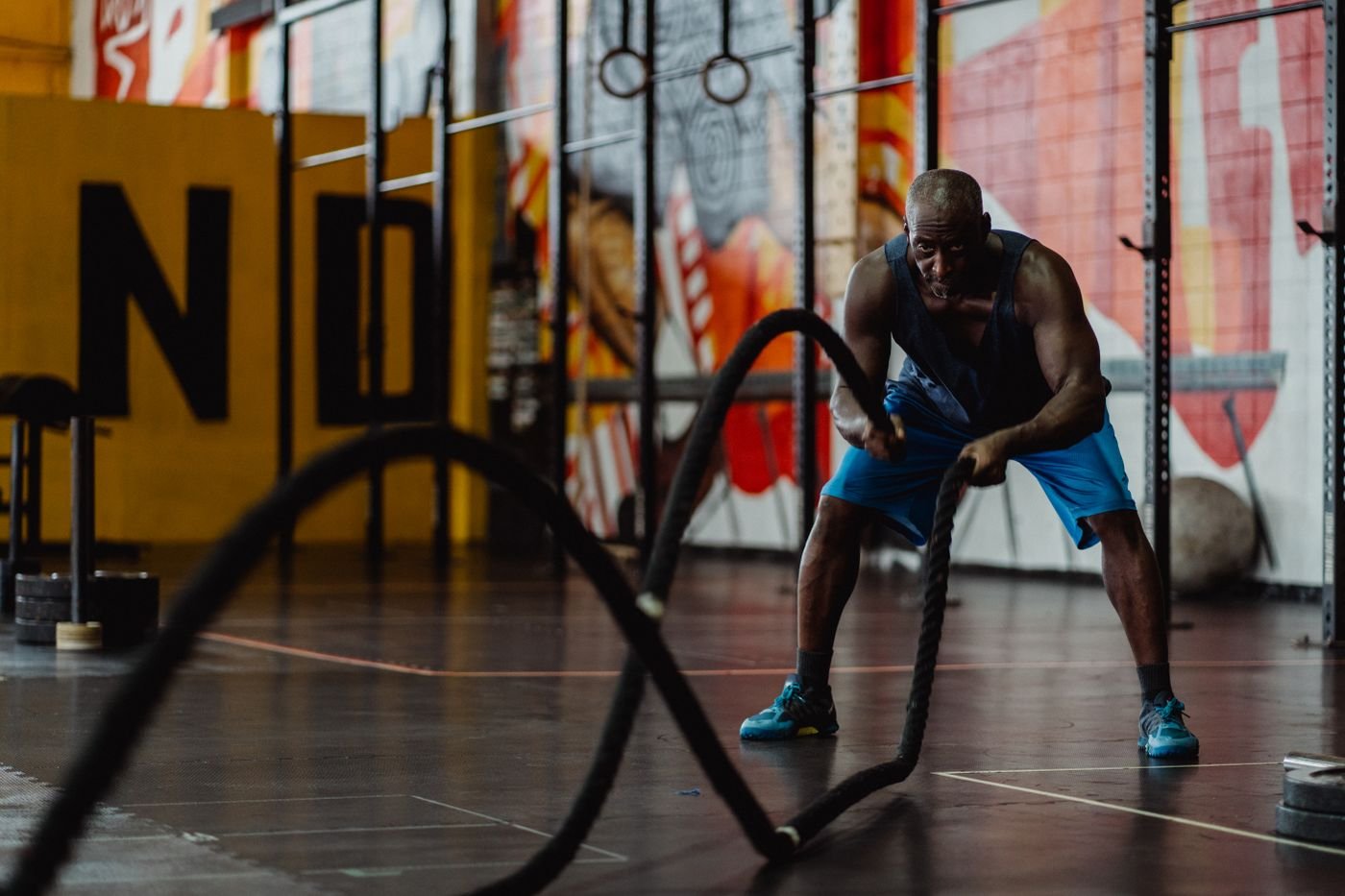 Athlete performing battle rope conditioning in an indoor gym
