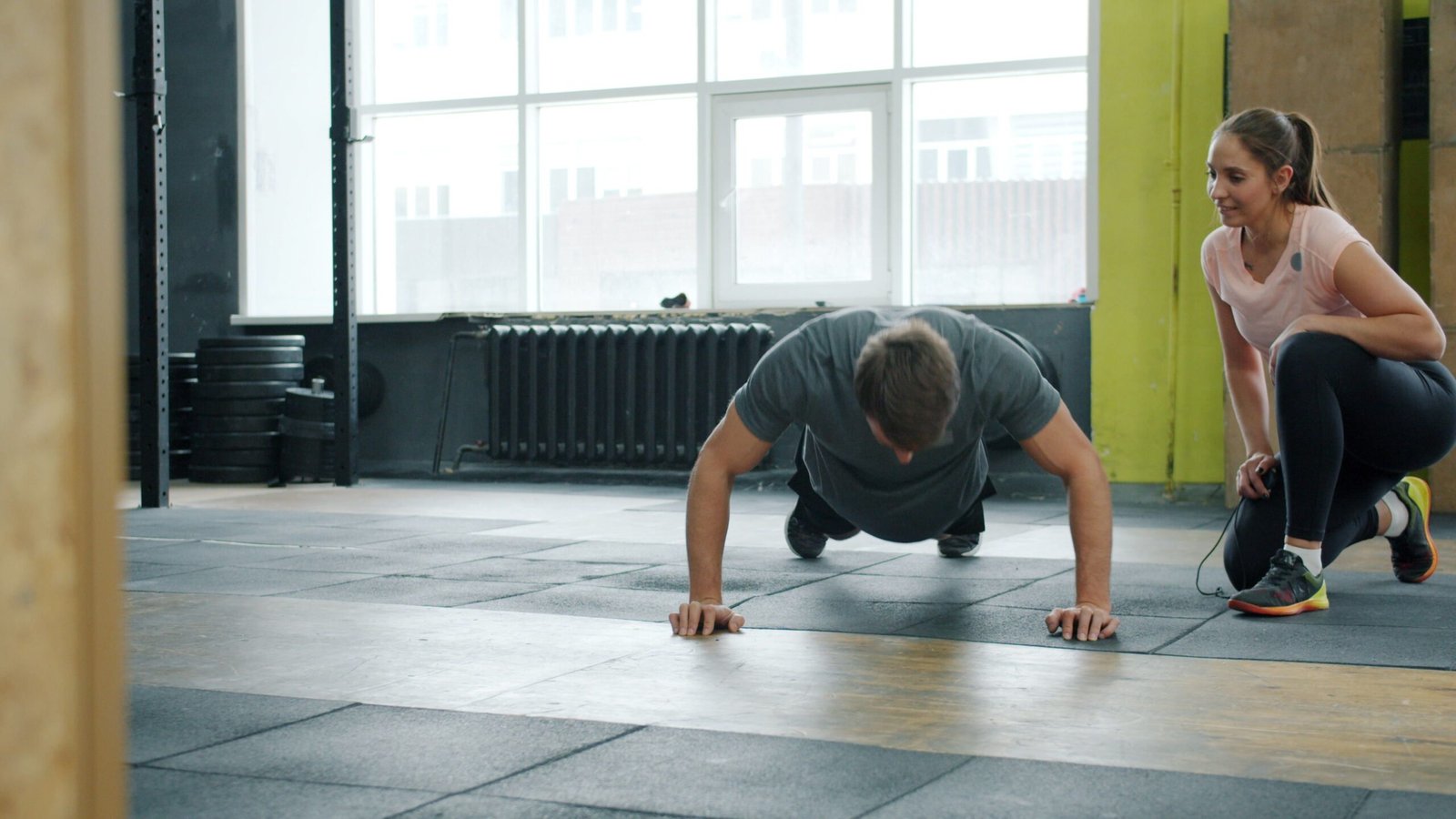 Coach supervising an athlete performing push-ups
