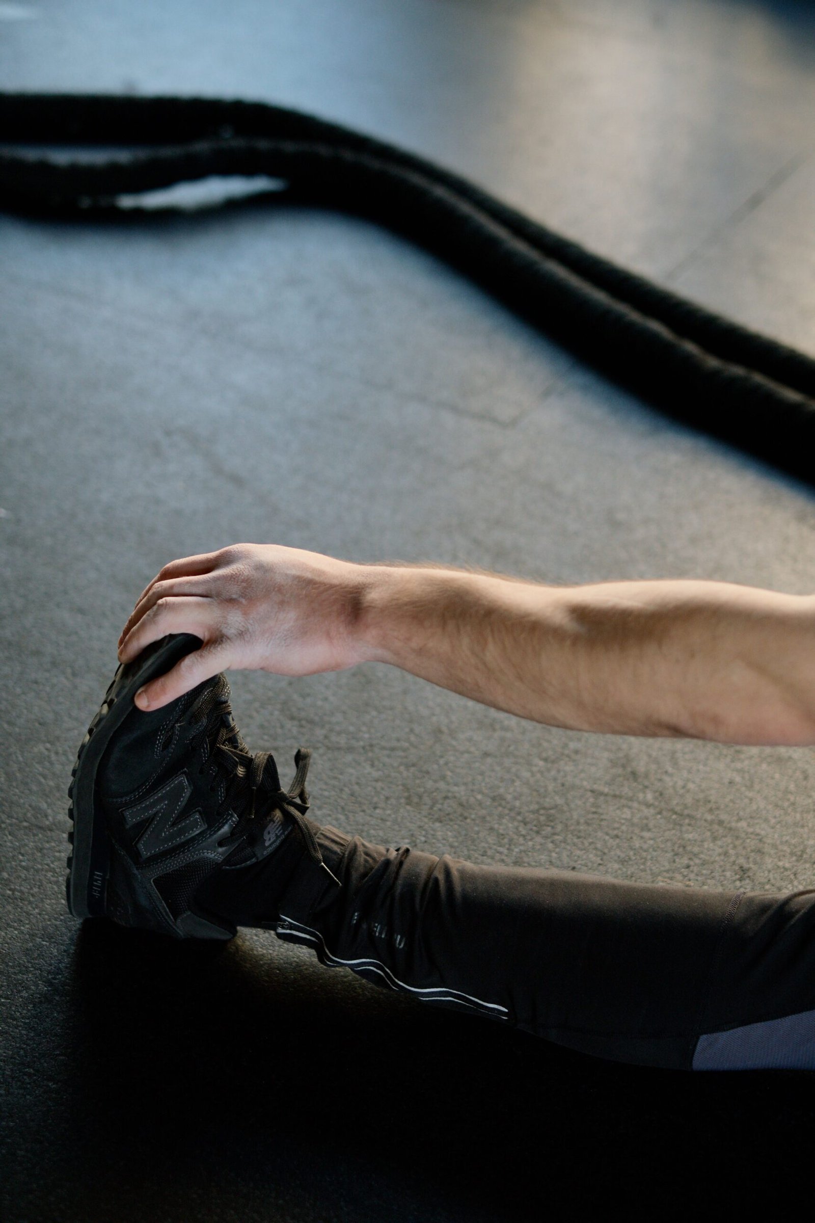 Athlete stretching a leg on the gym floor before training