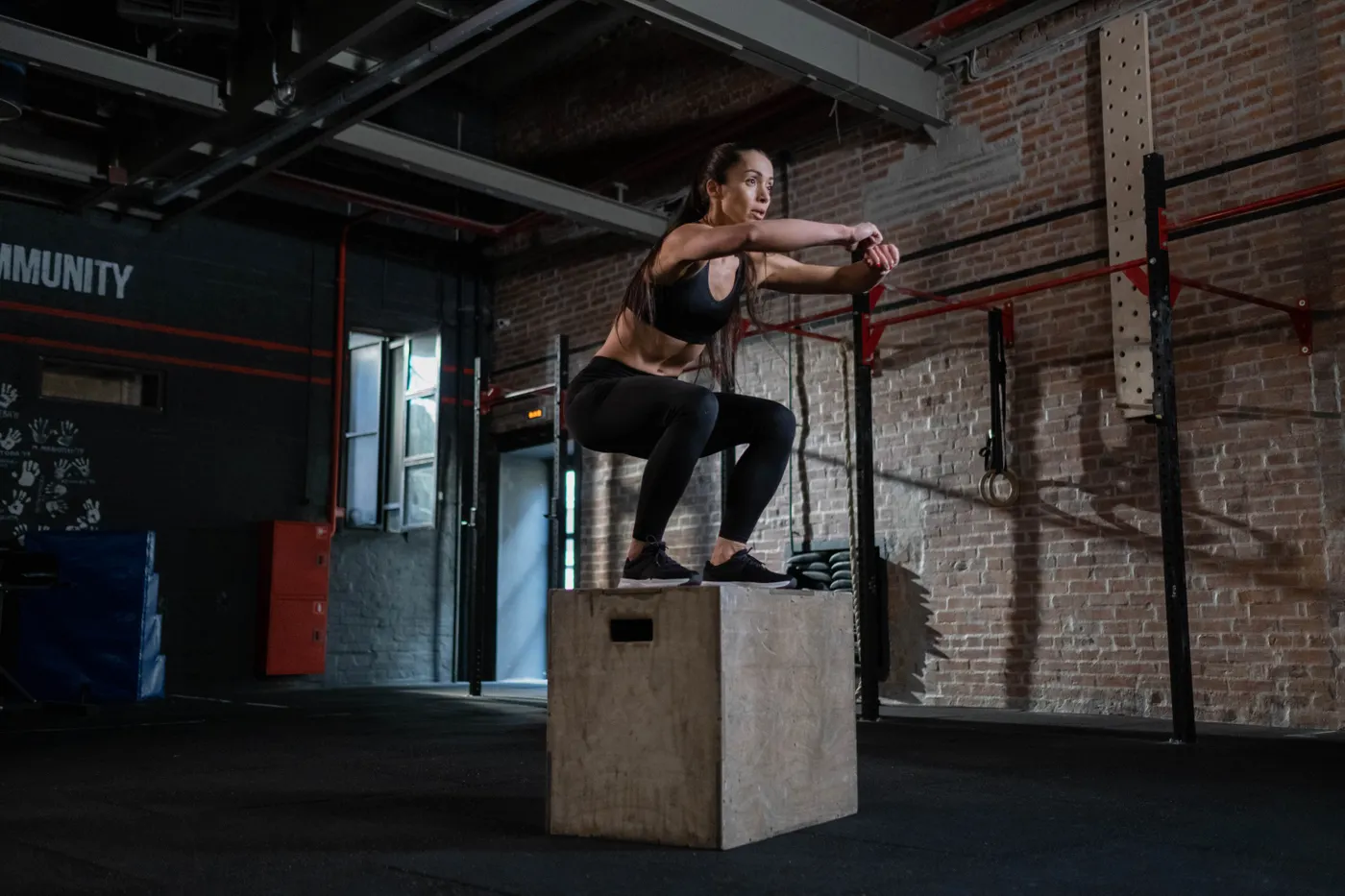 Athlete performing an explosive box jump in a gym