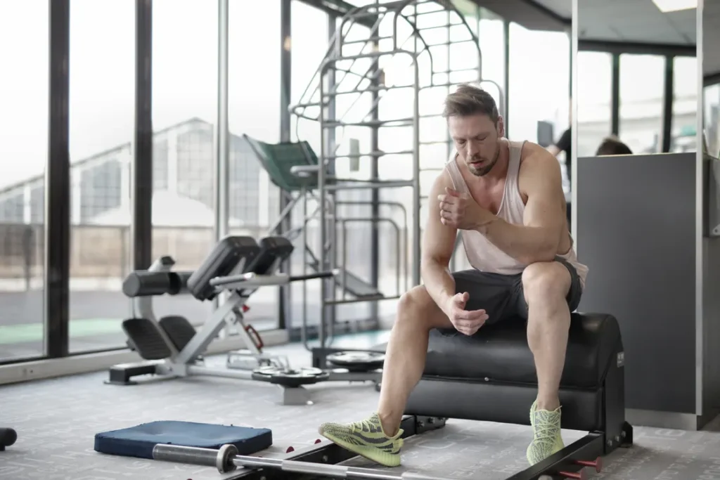 Lifter seated on a bench recovering after a weight-training session