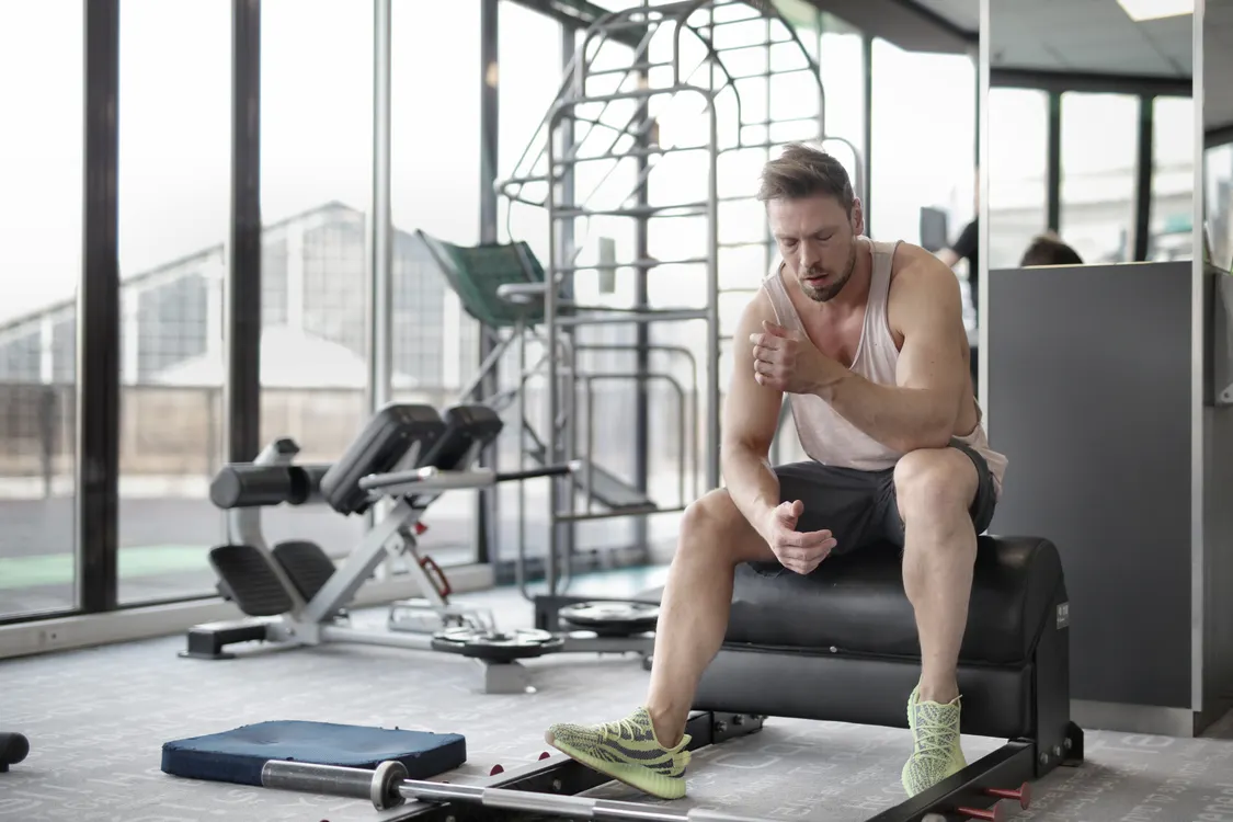 Lifter seated on a bench recovering after a weight-training session