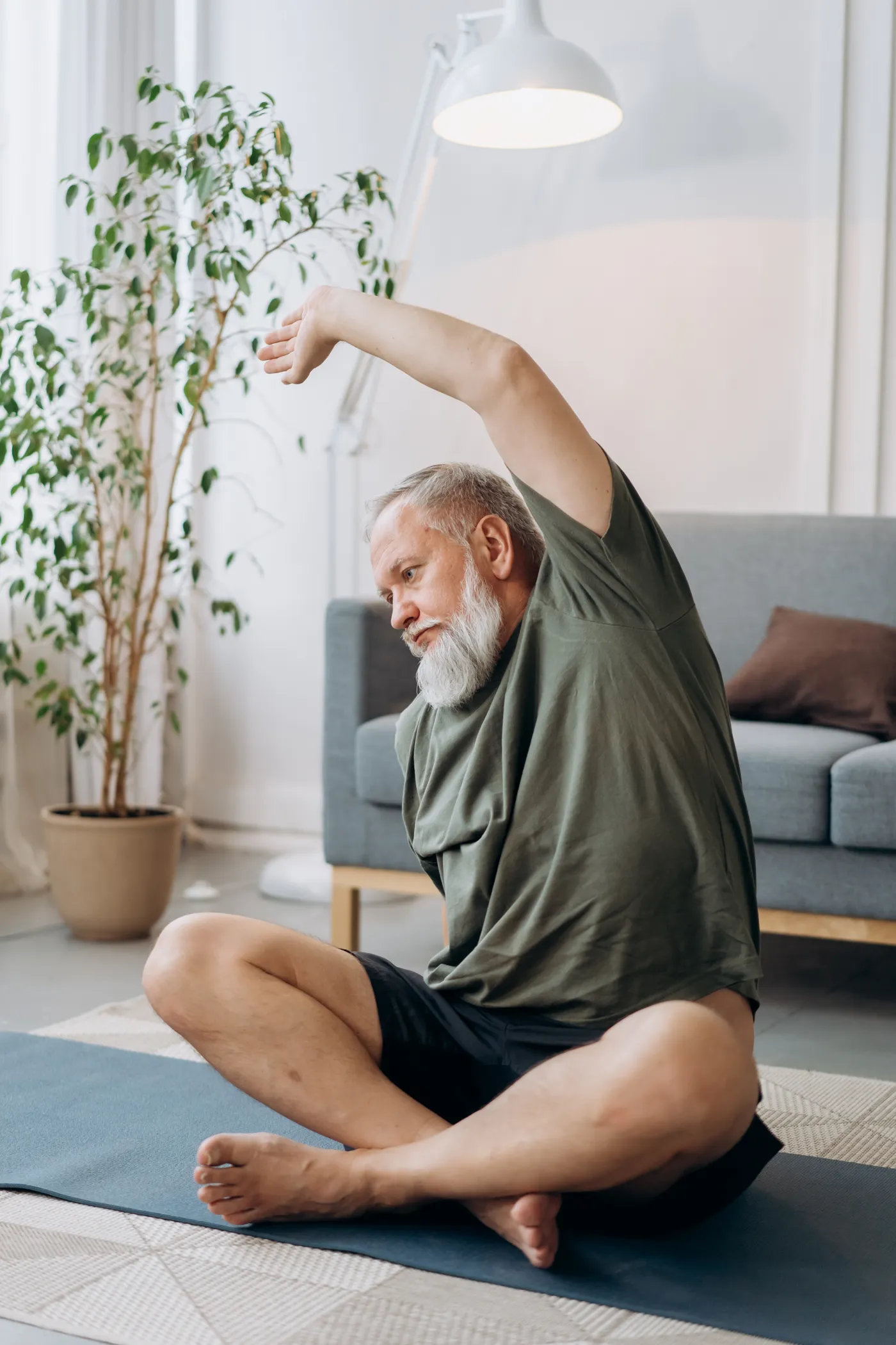 Older man exercising on a mat at home