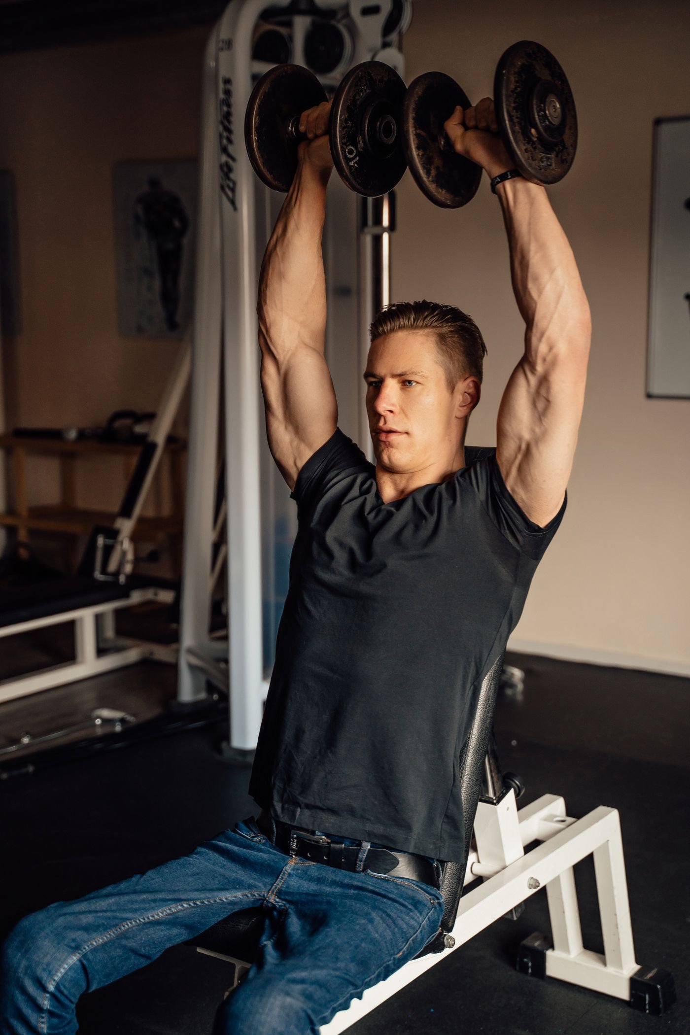 Man lifting dumbbells in an overhead shoulder press