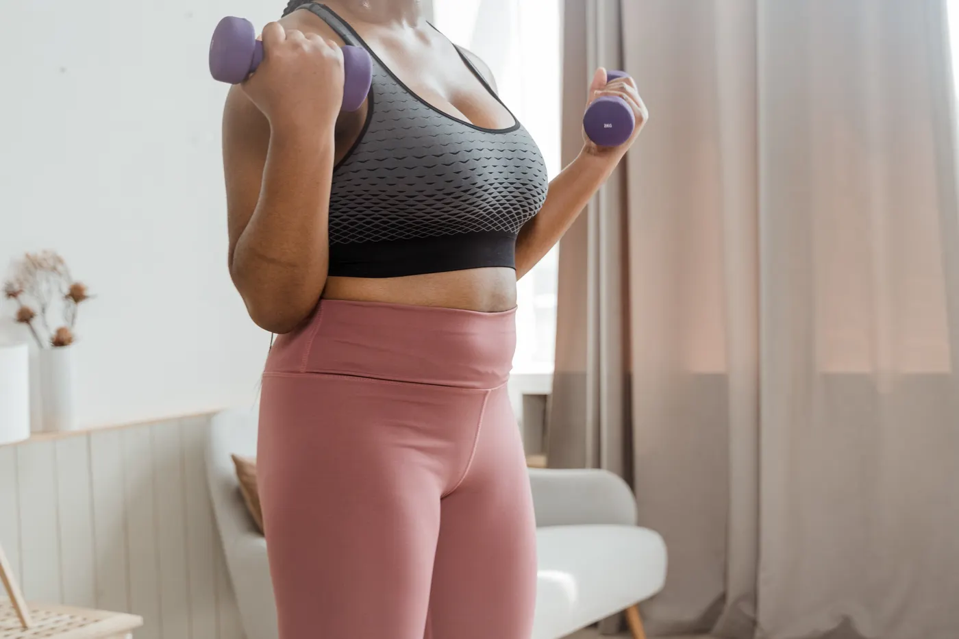 Woman training with dumbbells indoors