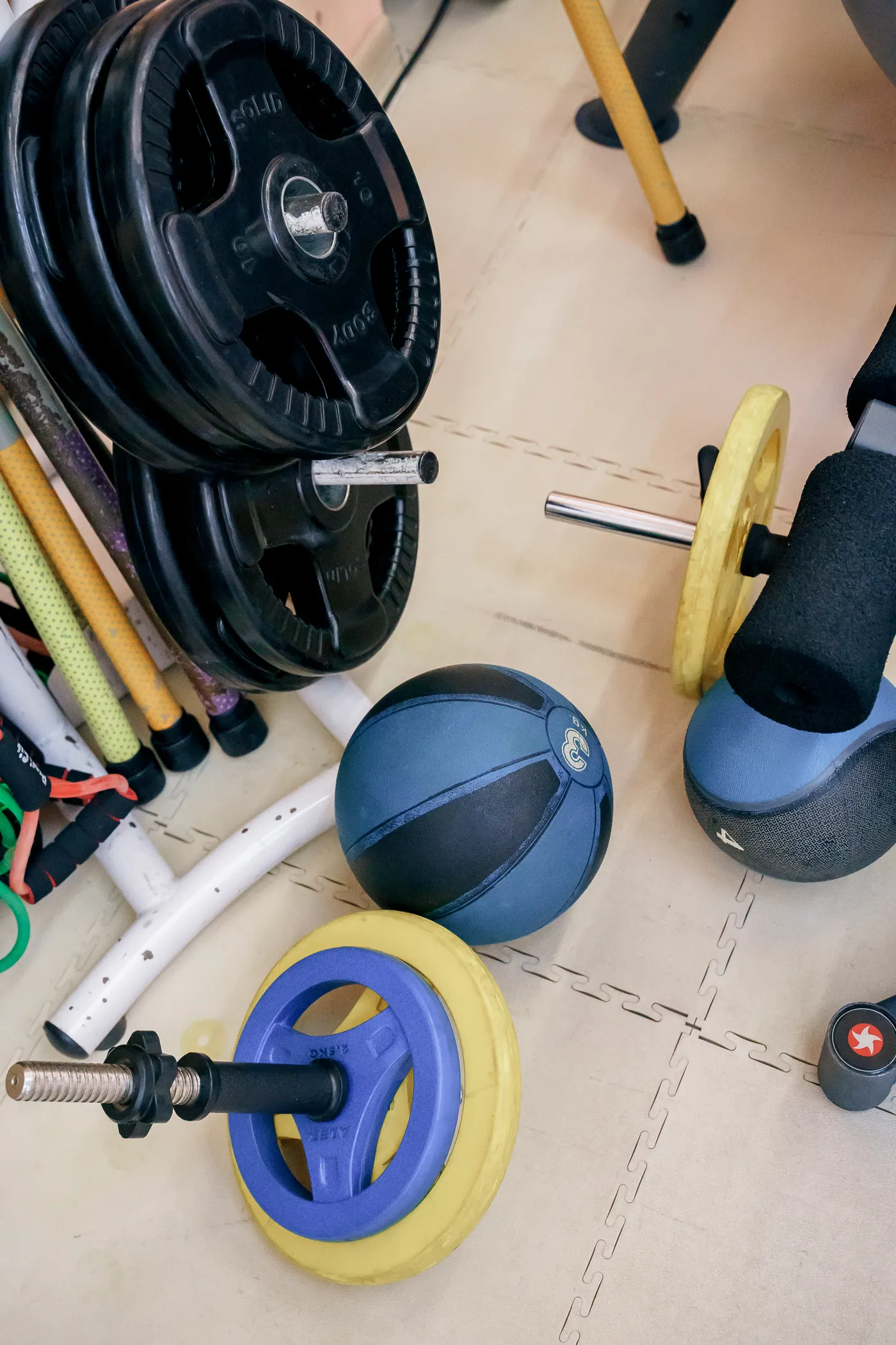 Assorted free weights, kettlebells and weight plates in a fitness room