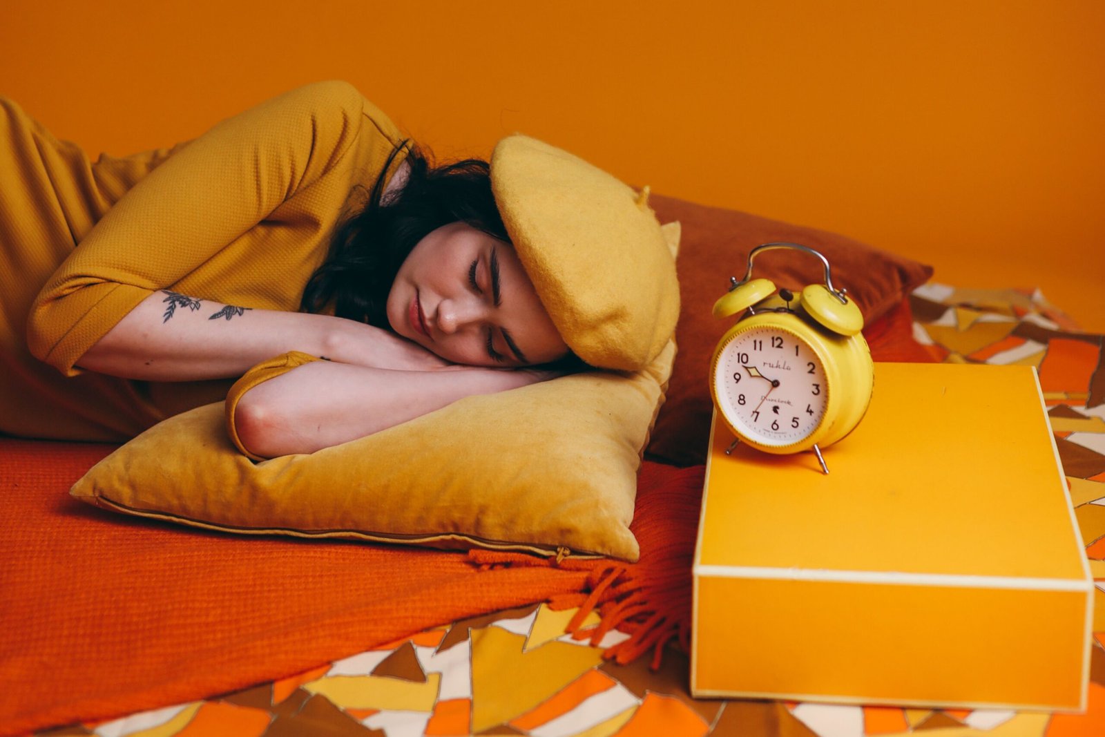Woman lying in bed beside an alarm clock