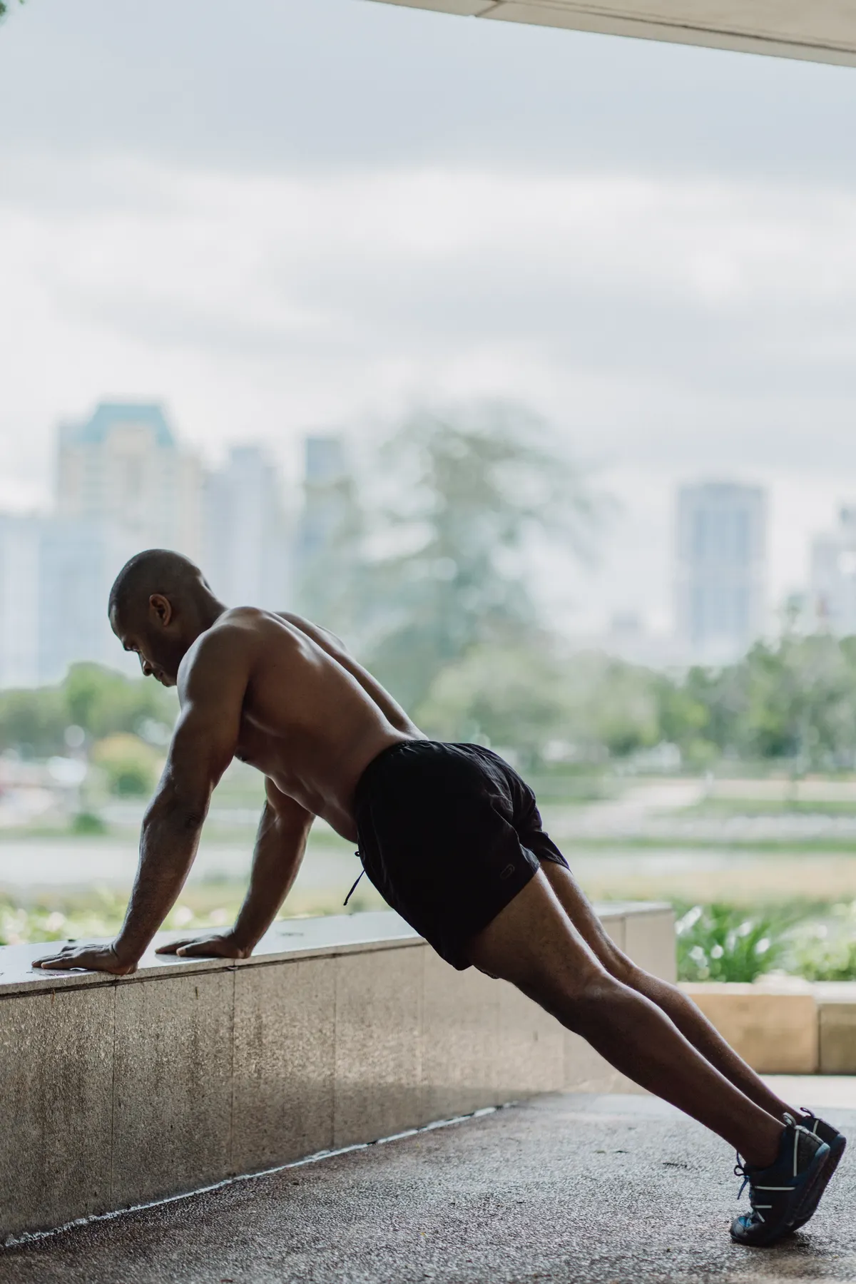 Athlete demonstrating an incline push-up against a concrete ledge