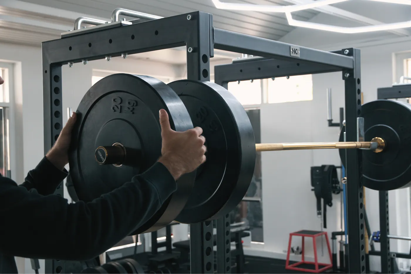 Lifter adjusting weight plates on a barbell