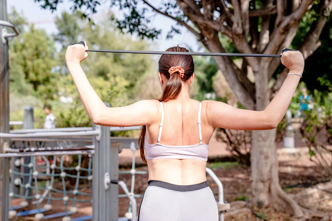 Woman using a resistance band during an outdoor fitness session
