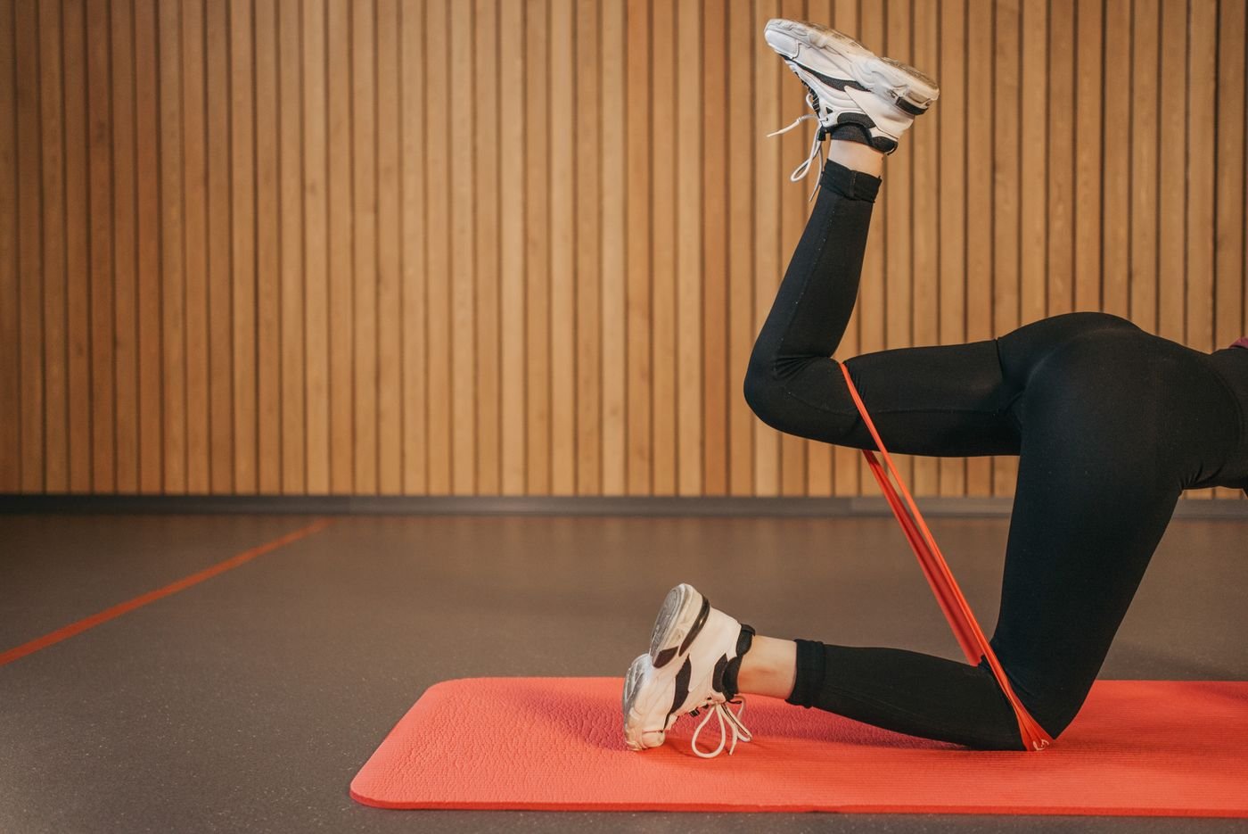 Athlete strengthening the legs with a resistance band on a mat