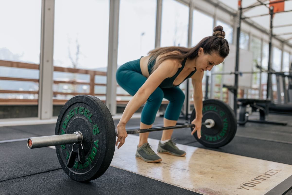 Woman preparing to lift a barbell in a training room