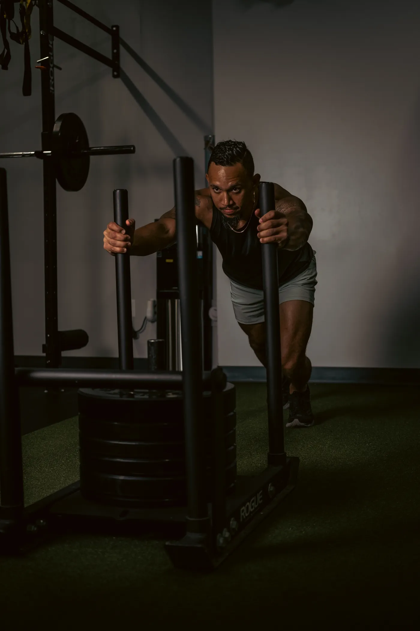 Athlete driving a loaded sled indoors