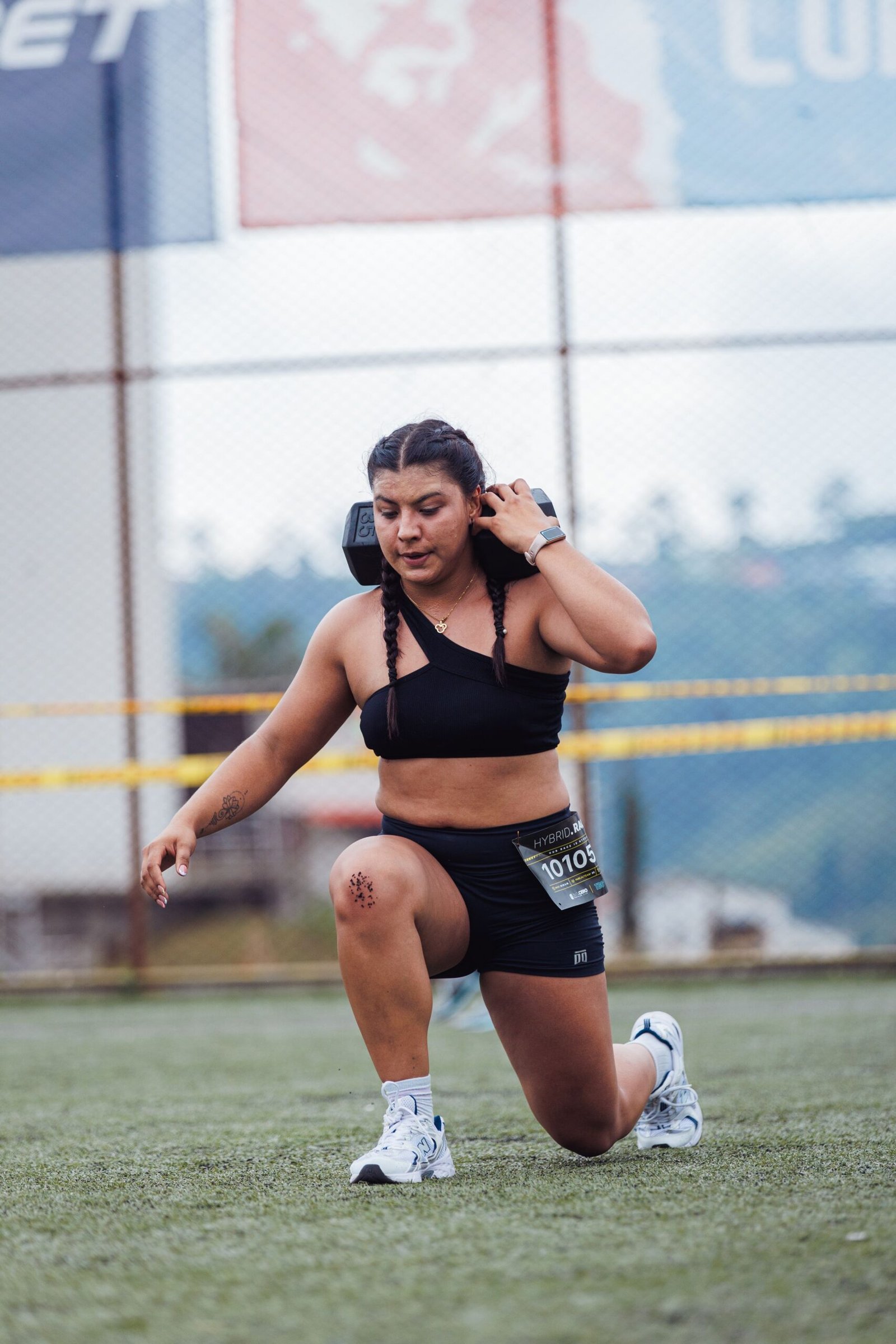 Athlete performing a weighted forward lunge on a sports field