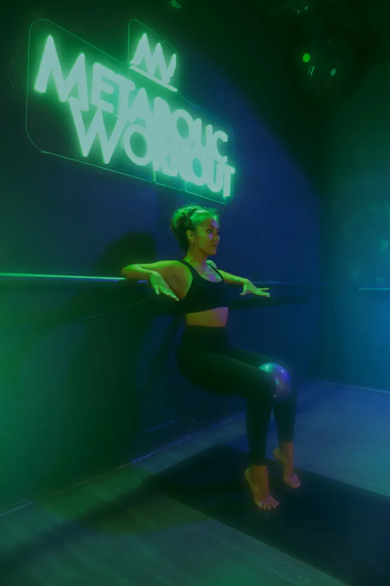 Woman holding a wall sit against a gym wall