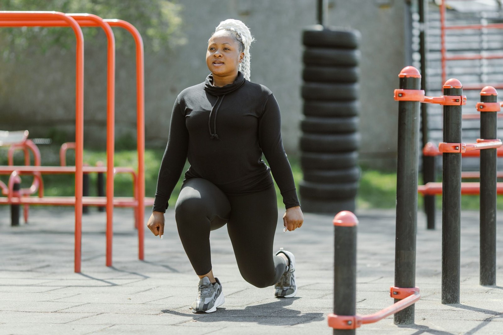 Woman performing a controlled lunge at an outdoor exercise park