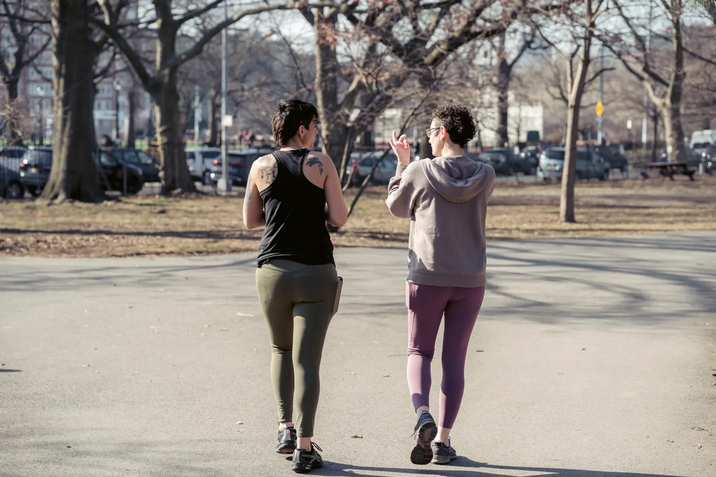 Two women walking together in an autumn park