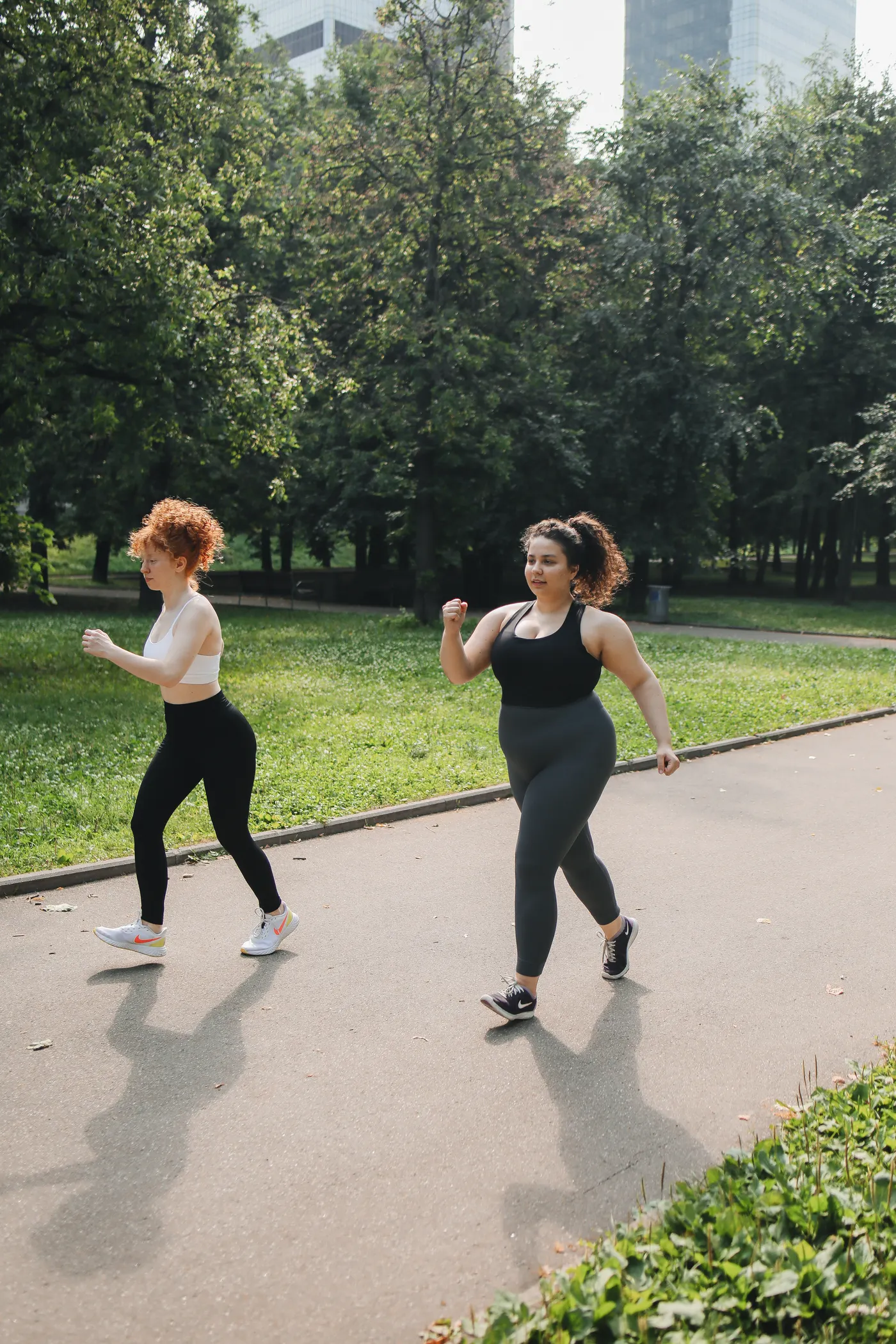 Two women brisk walking on a park pathway