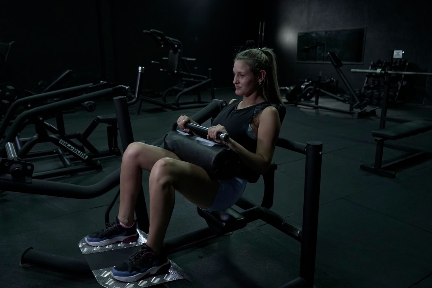 Woman exercising her legs on a seated gym machine