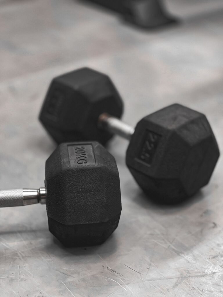 Two hex dumbbells on a gym floor representing simple strength training