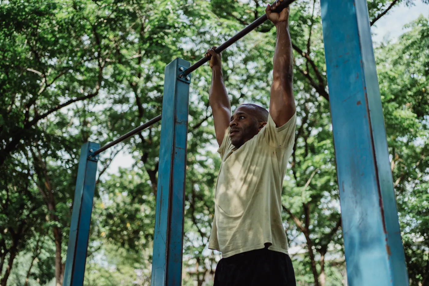 Athlete performing a pull-up on outdoor bars