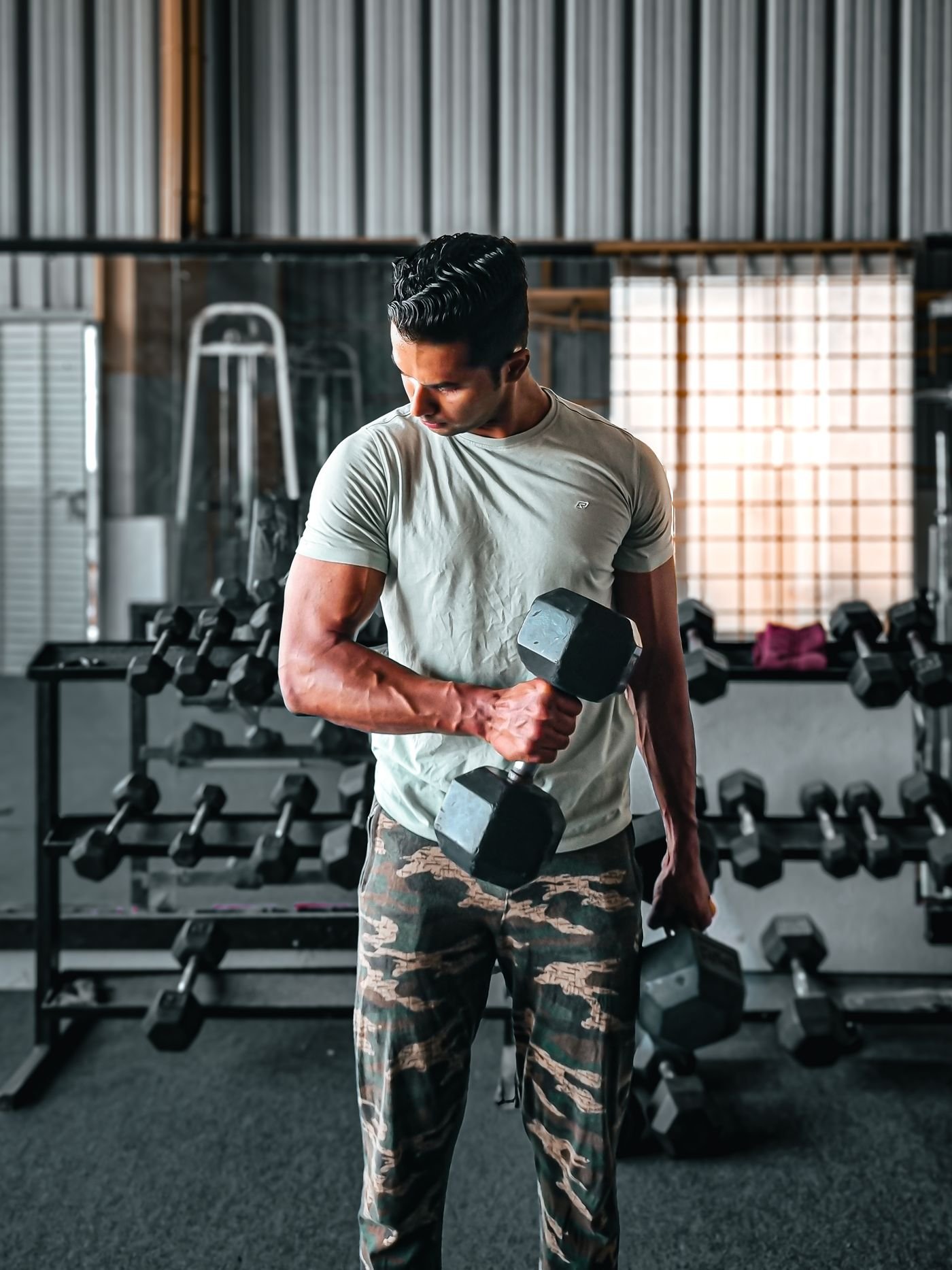 Man lifting a dumbbell in an indoor gym