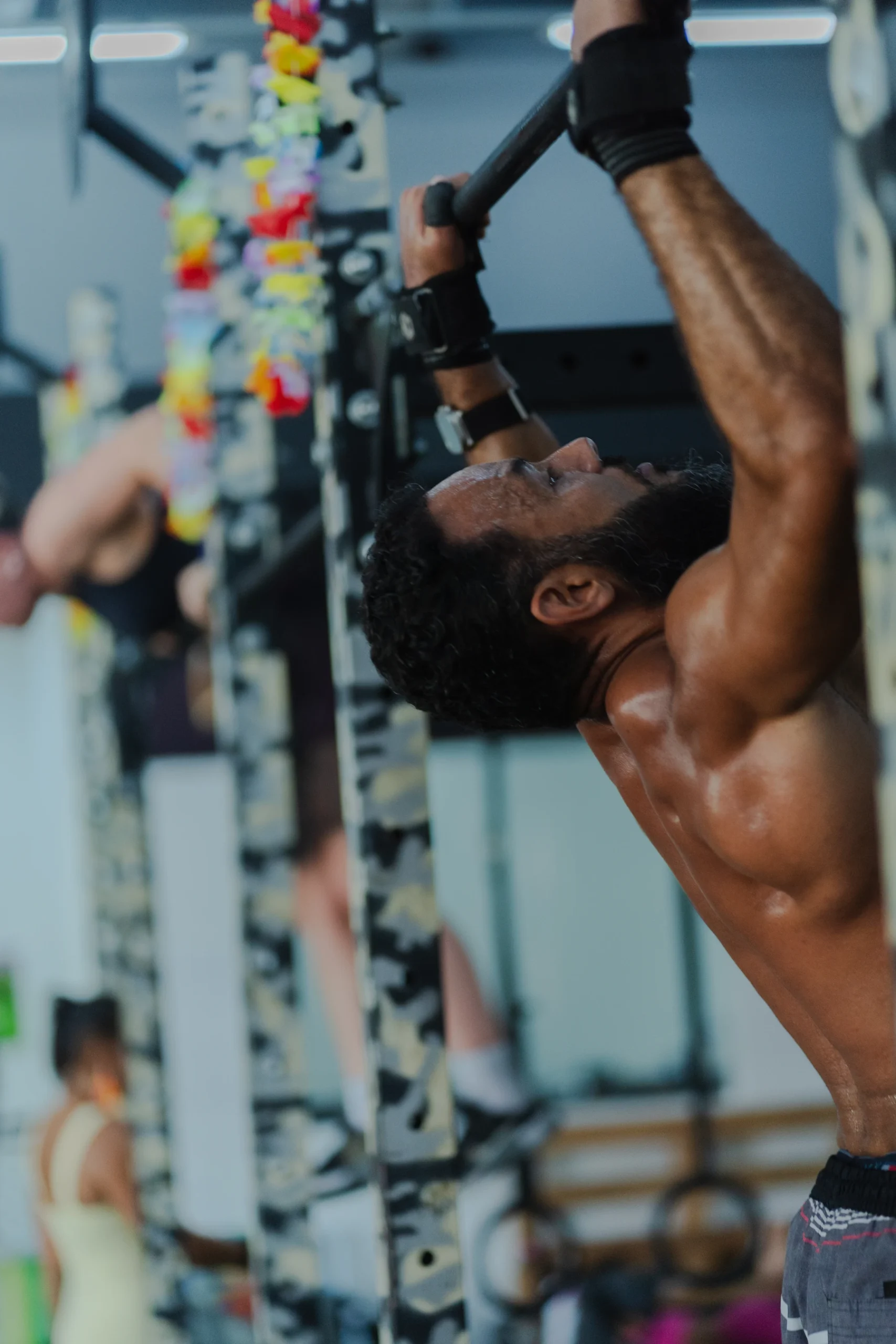Man holding a pull-up bar with both hands during a gym workout