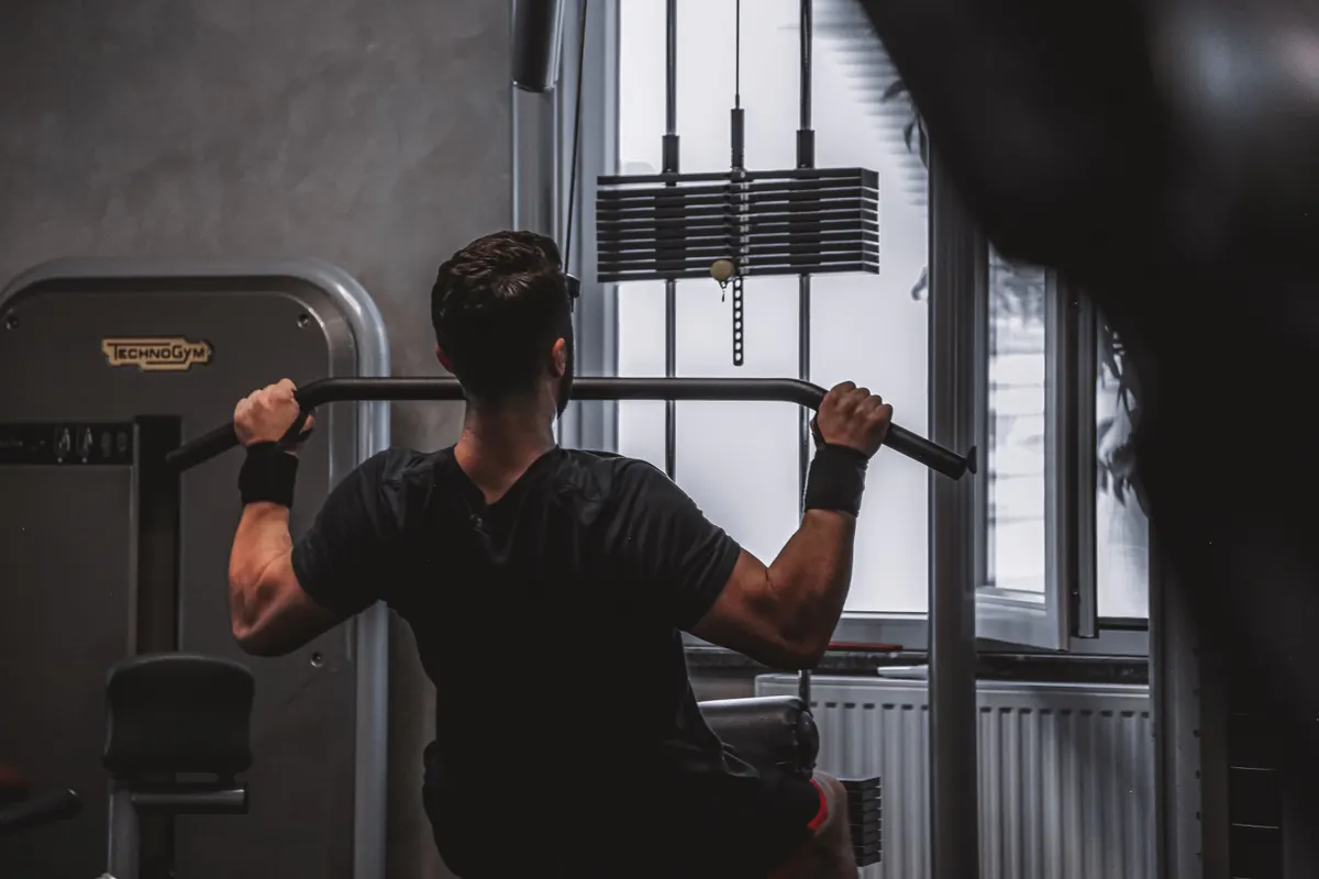 Rear view of a man performing a lat pulldown at a cable machine