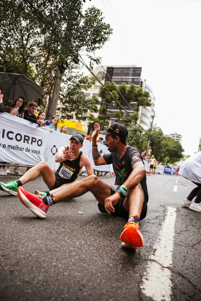 Two marathon runners celebrating after a race on a city street